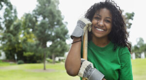 female volunteer in green top holding rake